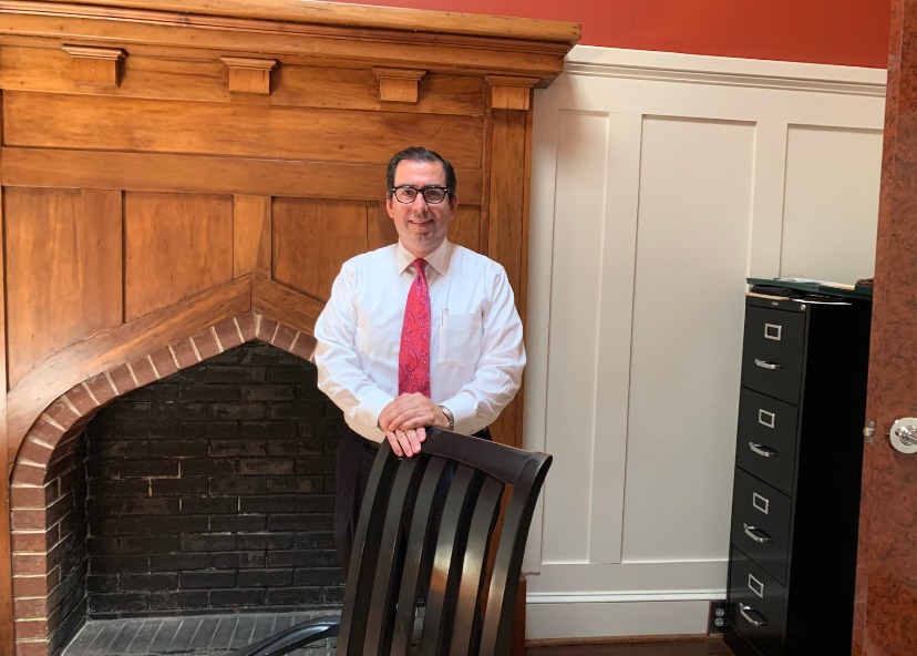 Keith Fitzgerald standing by office fireplace